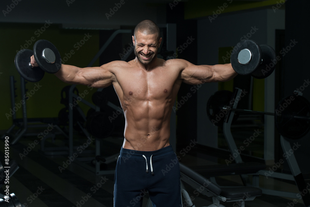 Male Bodybuilder Doing Heavy Weight Exercise For Shoulders