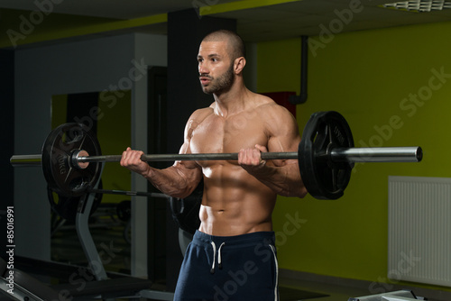 Bodybuilder Exercising Biceps With Barbell