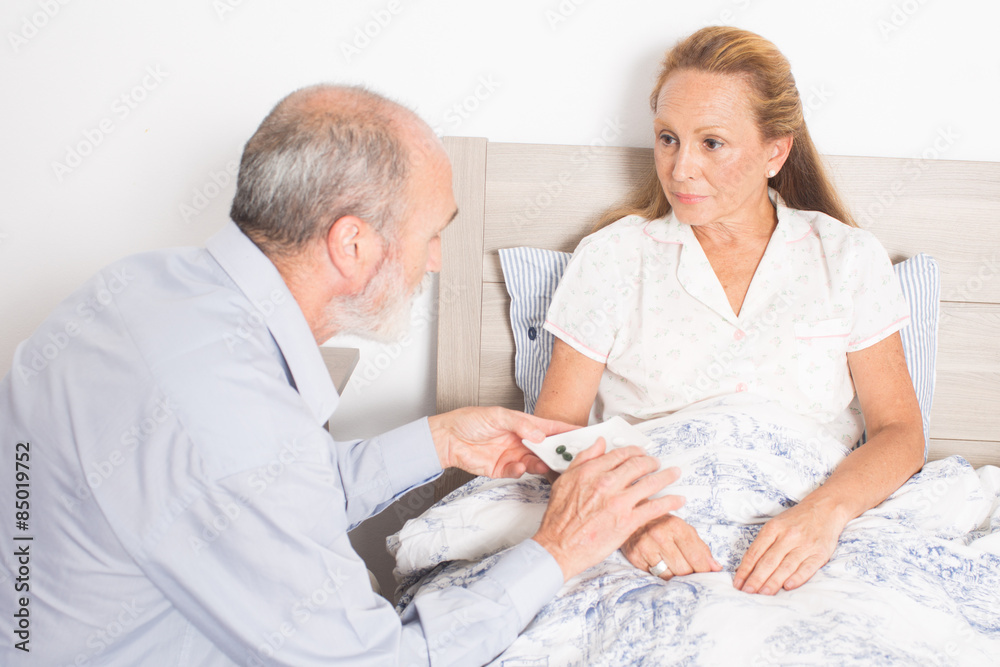 Mann gibt kranker Frau Medikamente