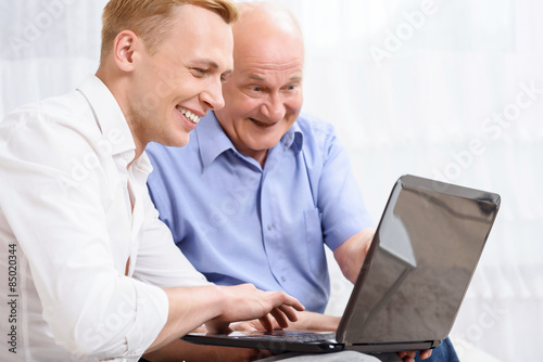 Grandfather and grandson with laptop 