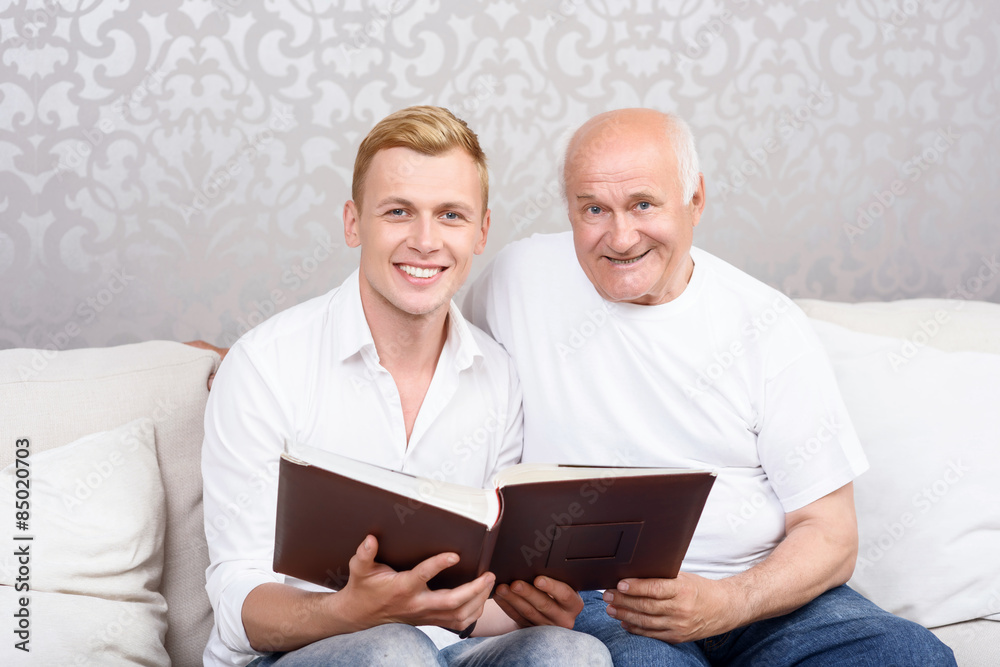 Grandfather and grandson sitting with album 