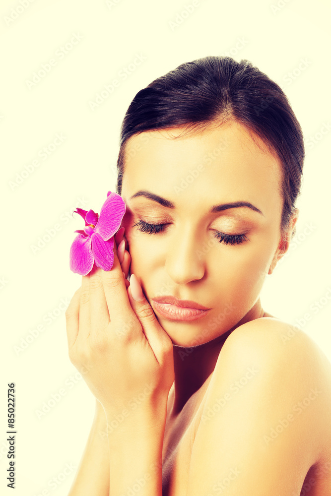 Naked woman with purple orchid petal near face Naked woman with purple orchid petal near face