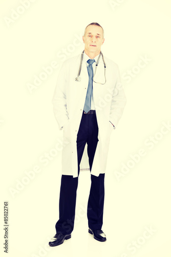 Male doctor with hands in pockets photo