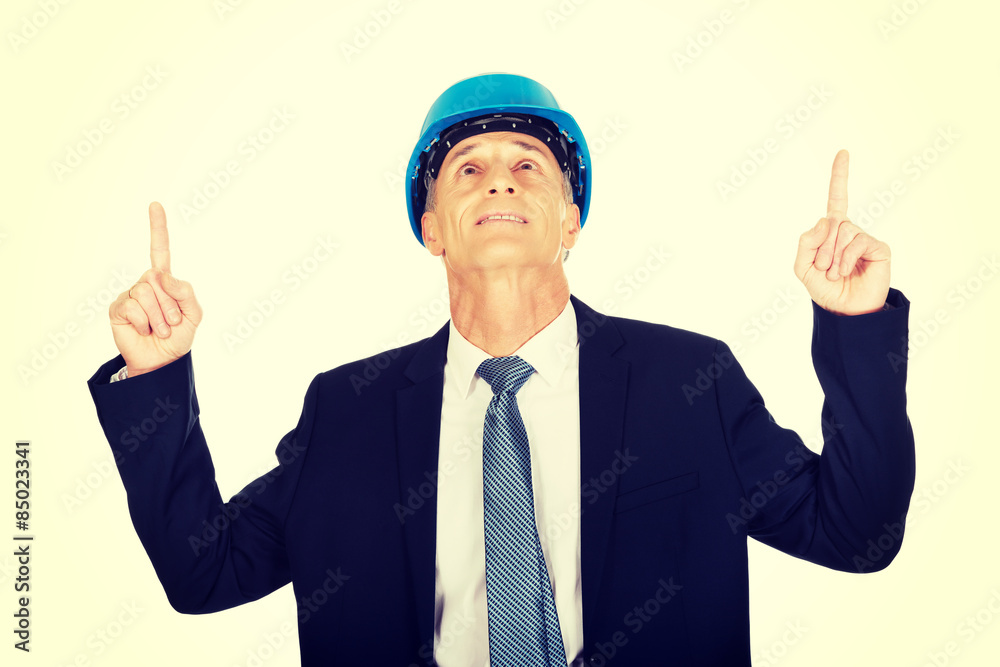 Portrait of businessman engineer pointing up