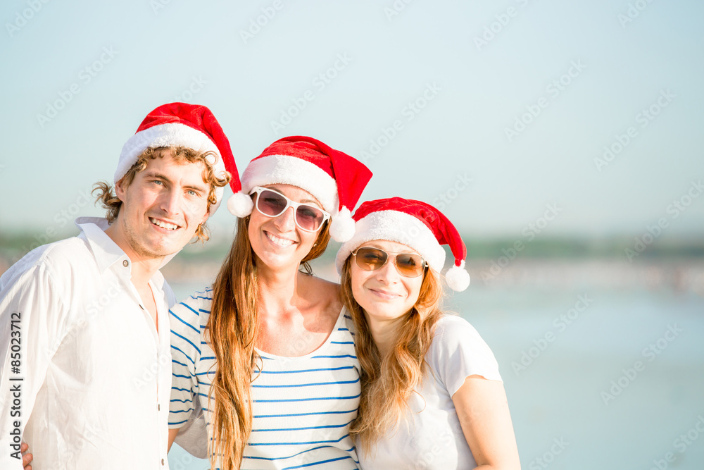 Group of happy young people in christmass hats on the beach Group of happy young people in christmass hats on the beach