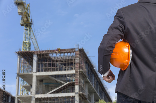 engineer holding orange helmet for workers security on contructi photo