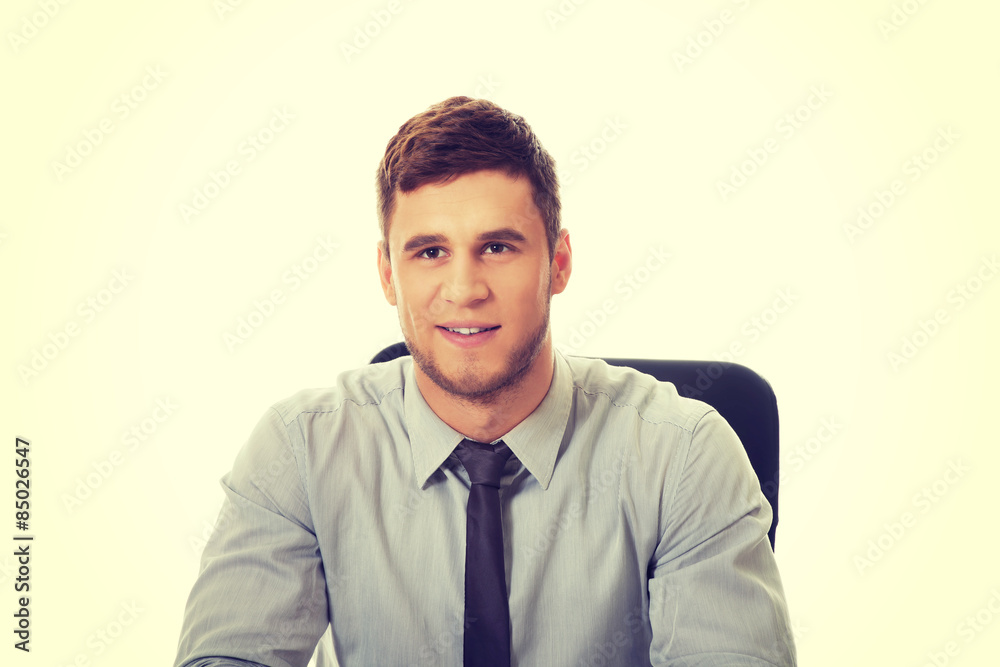 Businessman sitting by a desk in the office. Businessman sitting by a desk in the office.