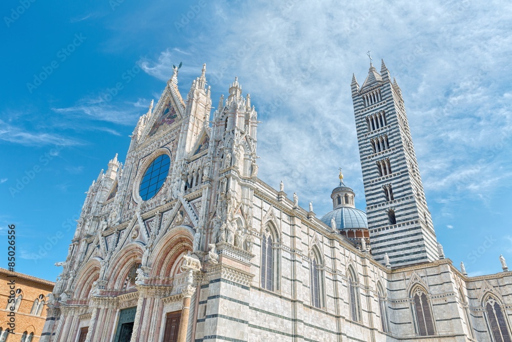 The main cathedral (duomo) in Siena Italy, with its dome and tall striped tower.