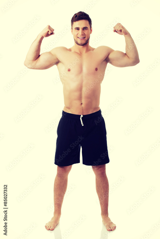Young athletic man showing his muscles.