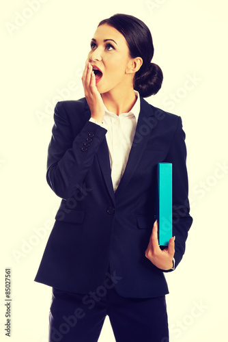 Shocked businesswoman holding a binder