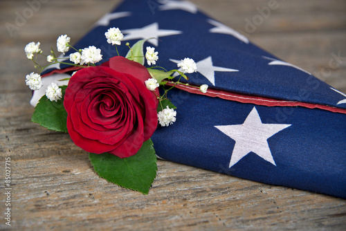 red rose in folded American flag
