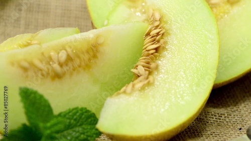 Juicy honeydew melon on a wooden table background.