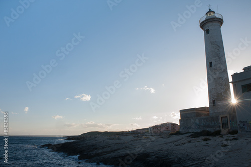 Lighthouse before the sunset and the sunrays behind it © siculodoc