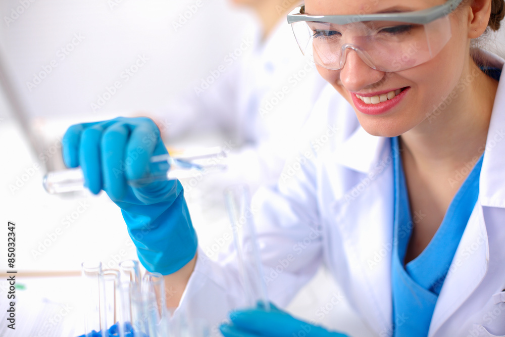 Woman researcher is surrounded by medical vials and flasks Woman researcher is surrounded by medical vials and flasks