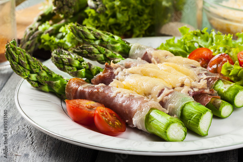 Baked green asparagus with prosciutto and cheese