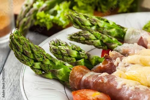 Baked green asparagus with prosciutto and cheese