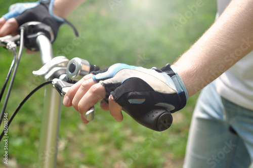 Young man is riding a bike, closeup on his hands