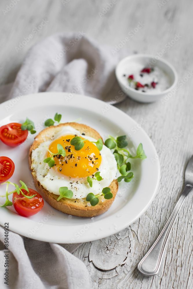 toast with egg and tomatoes on a light wooden surface toast with egg and tomatoes on a light wooden surface