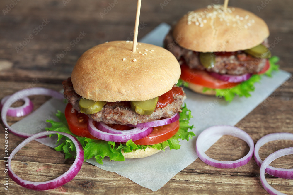 Homemade burgers with green salad, tomato, red onion, beef