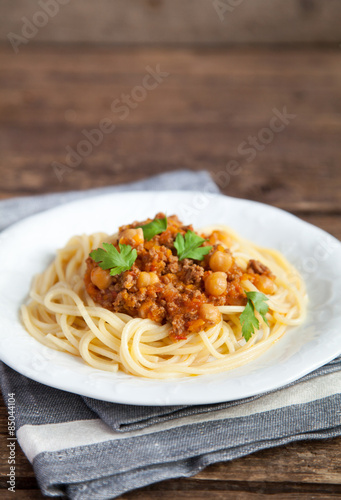 Spaghetti with tomato meat sauce, chickpeas and parsley