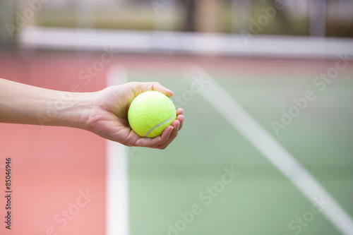 Tennis player holding the ball and getting ready to serve