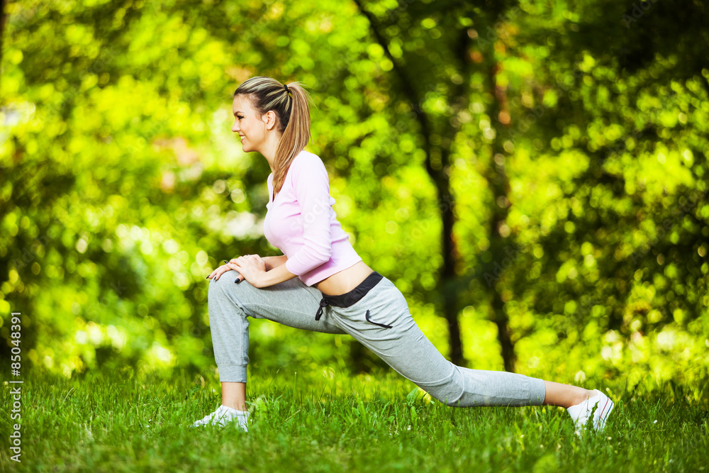 Woman stretching her body, warming up for jogging Woman stretching her body, warming up for jogging