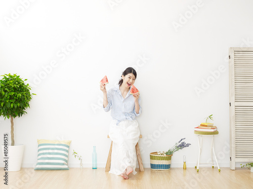 部屋で西瓜を食べる女性