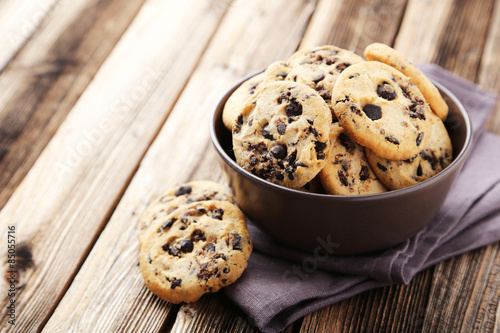 Foto Chocolate chip cookies in bowl on brown wooden background