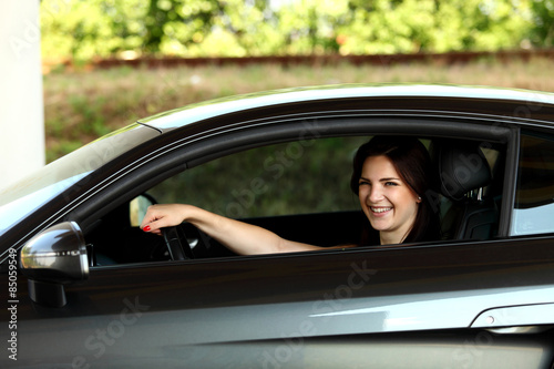 Uśmiechnięta dziewczyna w samochodzie.