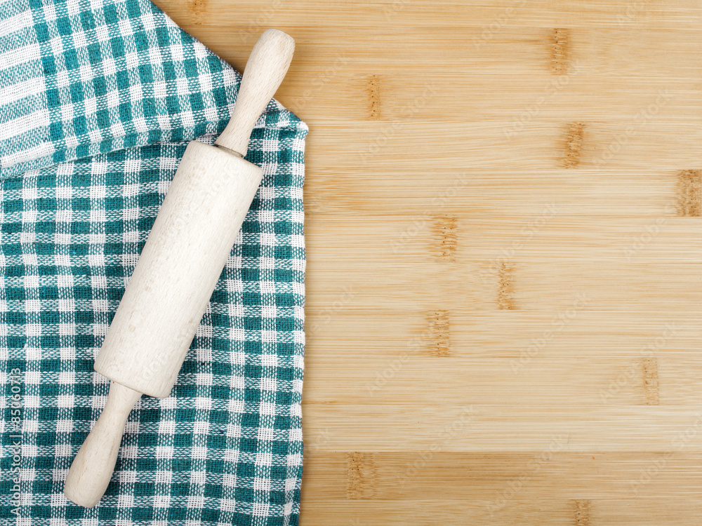 Wooden table covered with tablecloth cloth checkere and rolling pin