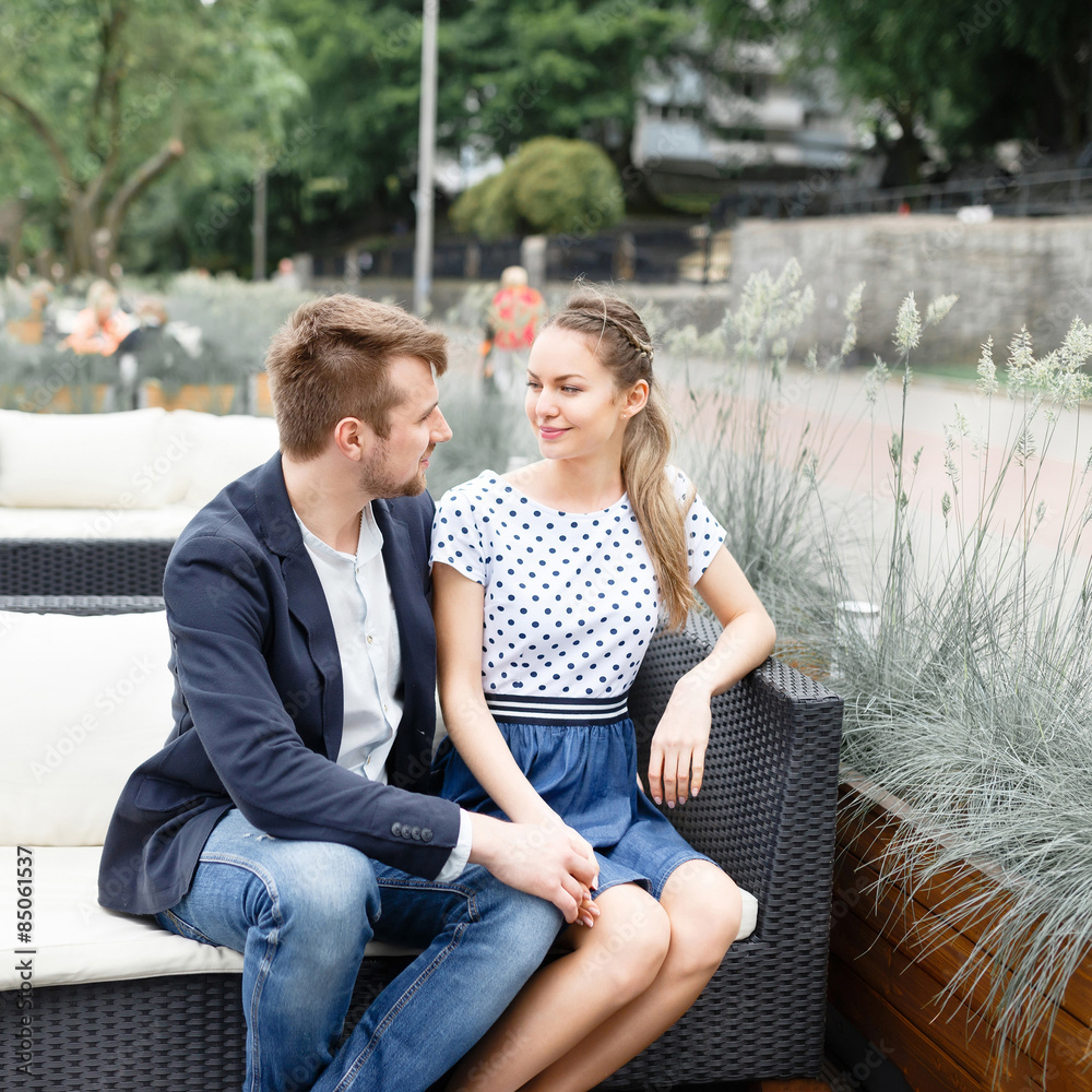 A young couple spends time on the couch in the outdoor cafe near the Baltic Sea A young couple spends time on the couch in the outdoor cafe near the Baltic Sea