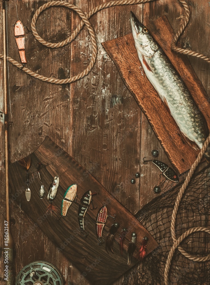 Fototapeta premium Fishing tools and fresh pike on a wooden table