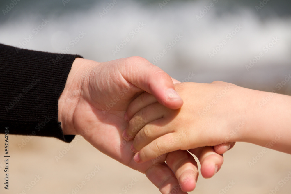 Frau hält reicht einem Kind die Hand Frau hält reicht einem Kind die Hand