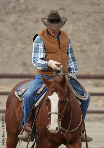 A western cowboy is training his horse by riding him.