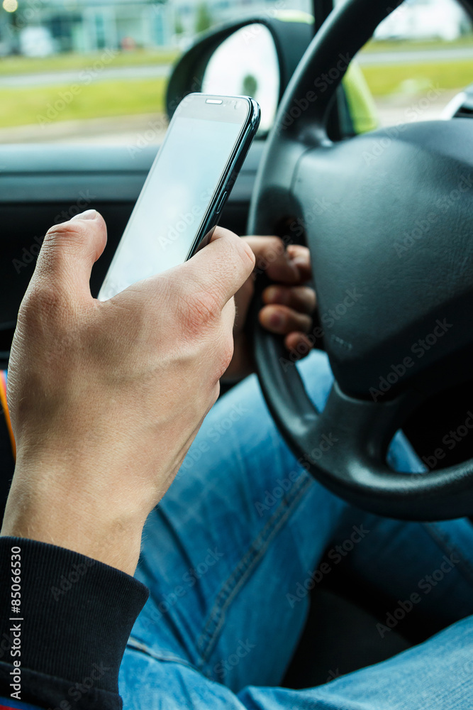 Male hand with smartphone in the car
