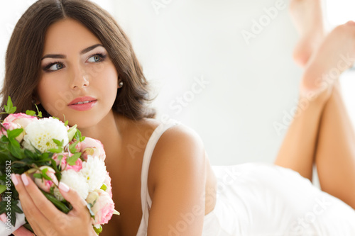 Obraz na plátně Beautiful bride in white lingerie holding nuptial bouquet