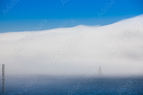 Lonely sailboat in the morning mist