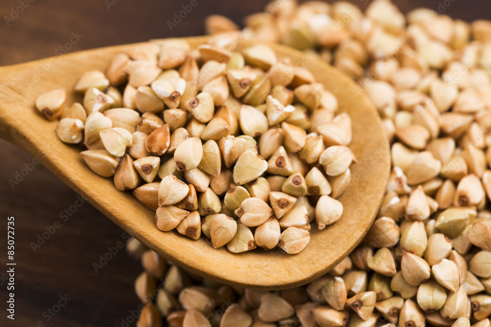 Buckwheat with a spoon on a wooden boards background Buckwheat with a spoon on a wooden boards background