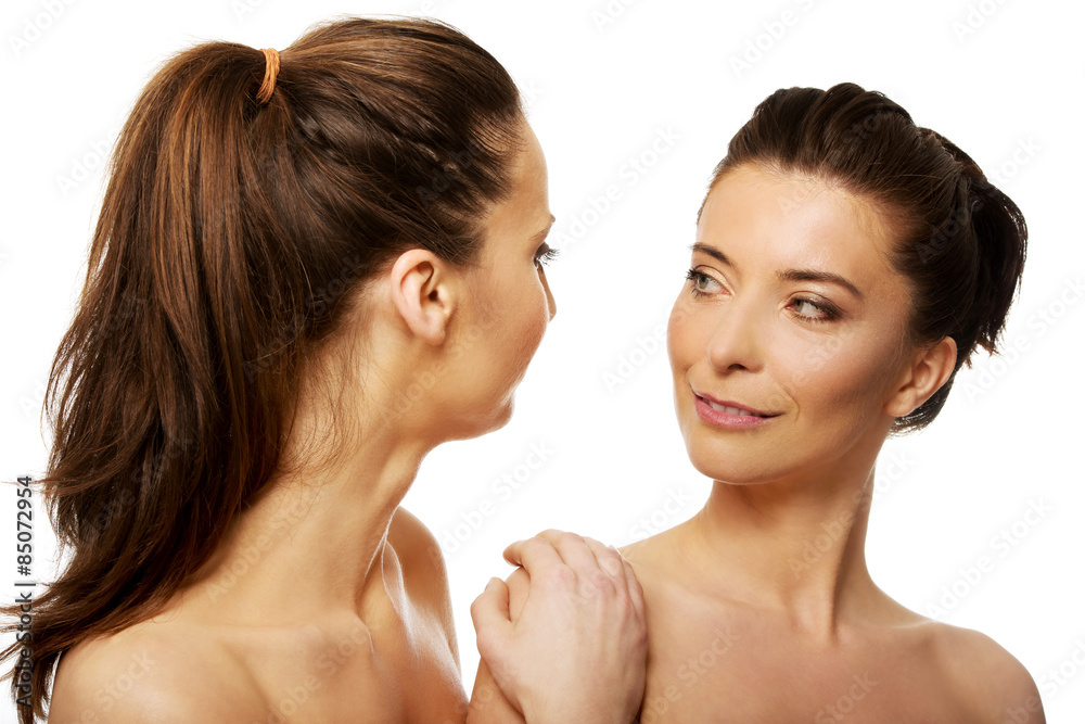 Two sisters with make up looking at each other.