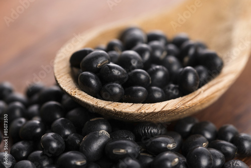 A lot of black soybeans on wooden background