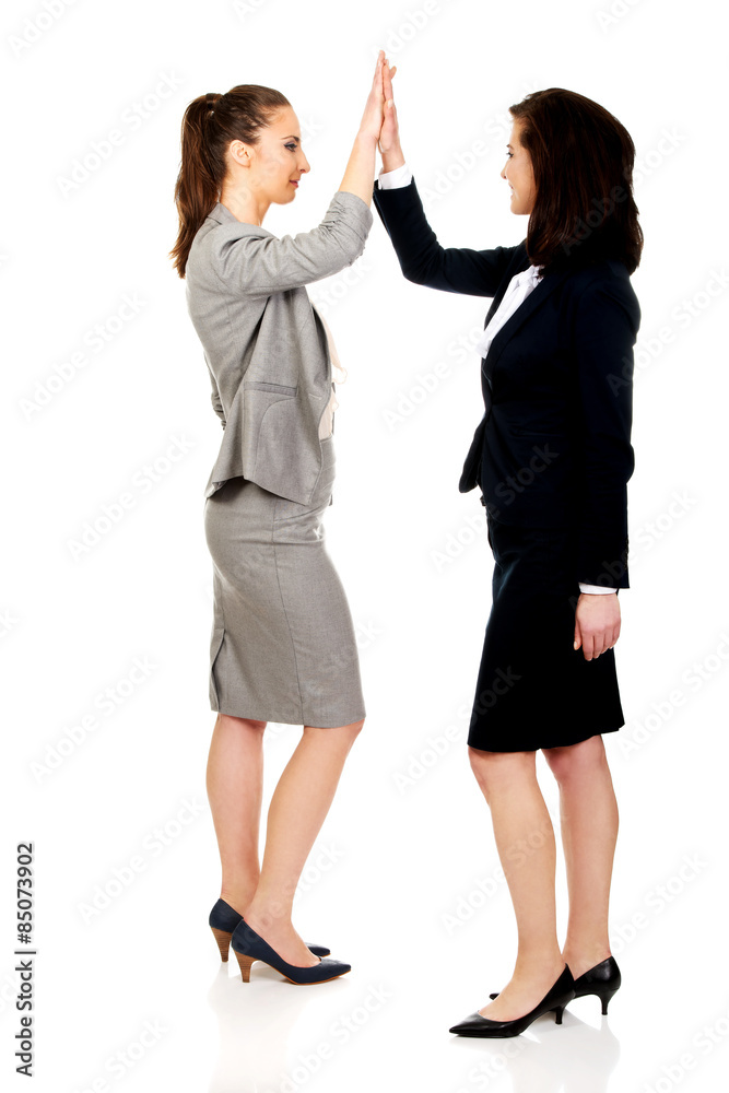 Two businesswomen giving a high five.