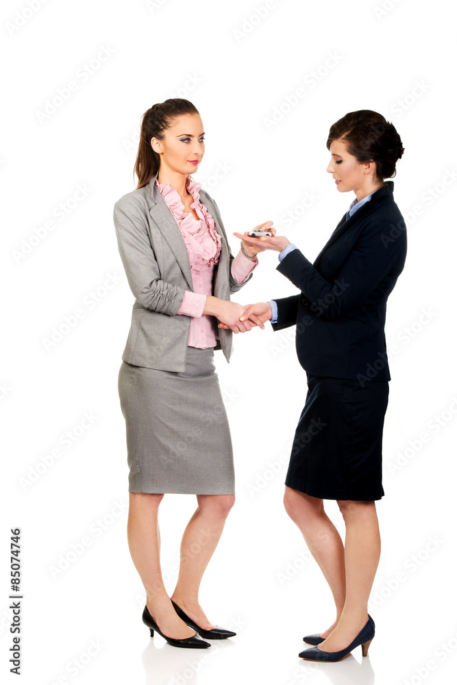 Businesswoman giving a key to her partner. Businesswoman giving a key to her partner.