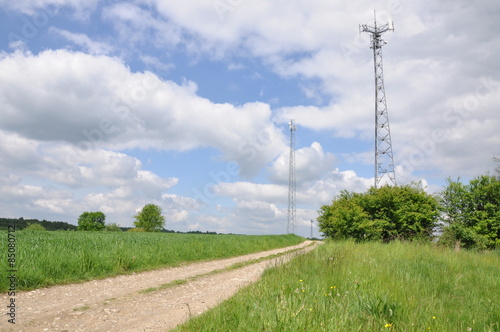 Telecommunication tower on the field against the sky 