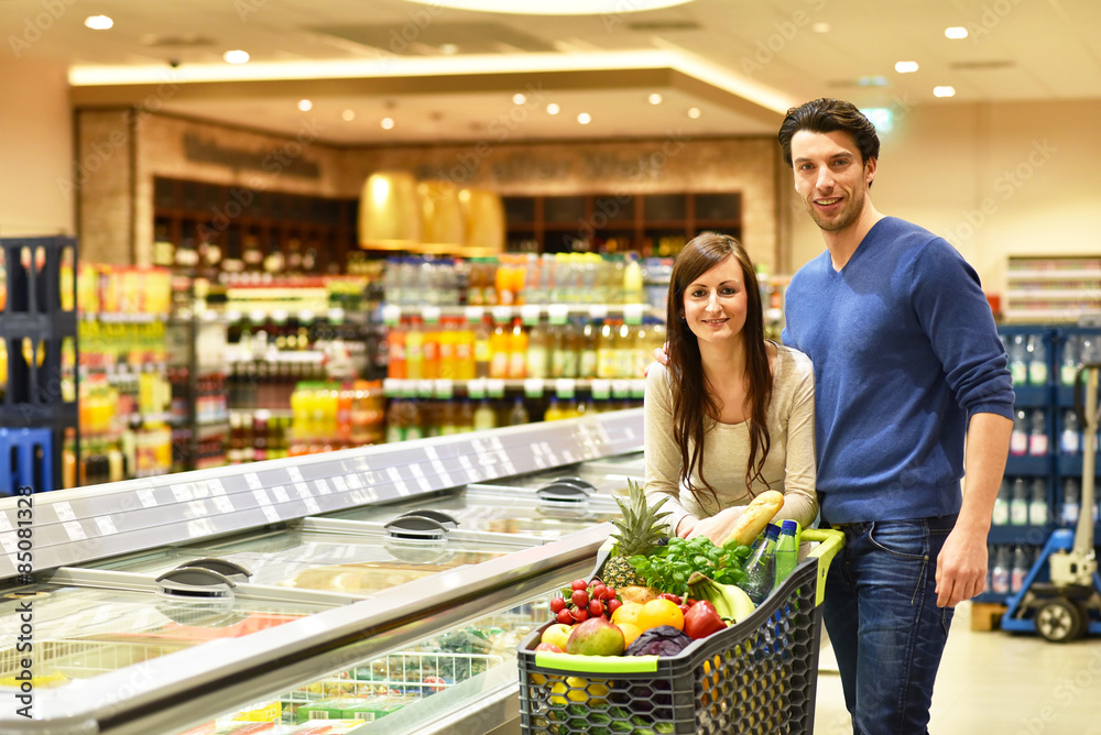 junges Paar beim einkaufen im Supermarkt mit Einkaufswagen