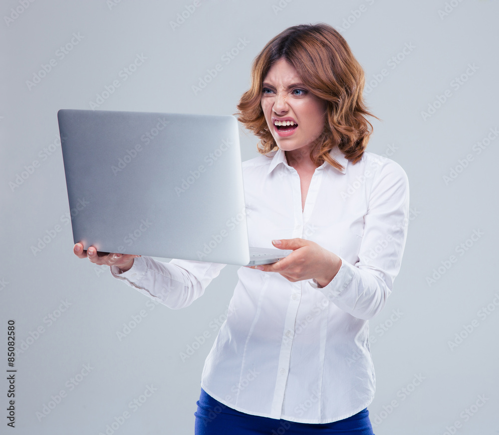Businesswoman with disgusted emotion holding laptop Businesswoman with disgusted emotion holding laptop
