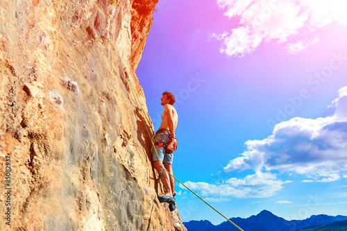 Rock climber climbing up a cliff