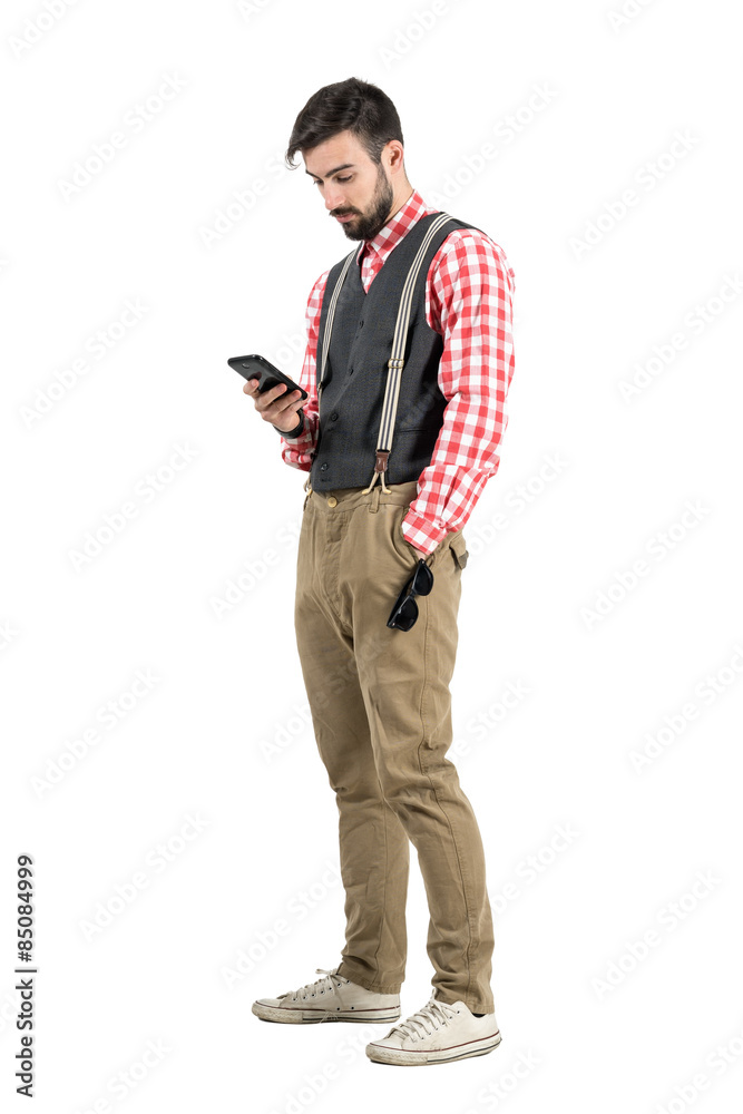 Relaxed young man in retro clothes using smartphone Relaxed young man in retro clothes using smartphone