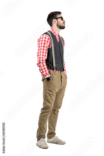Side view of young bearded hipster smoking cigarette
