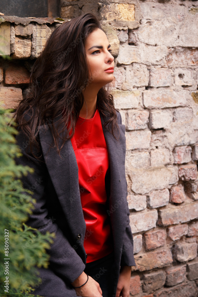 Slender girl posing on brick wall background