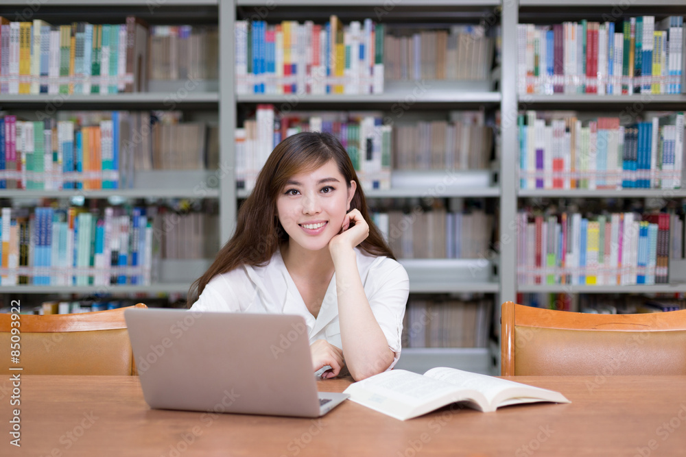 Beautiful asian female student using laptop for study in library Beautiful asian female student using laptop for study in library